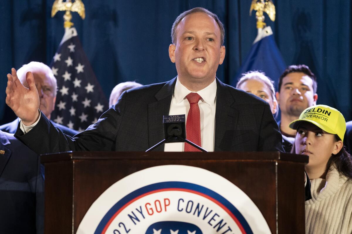 Lee Zeldin speaks from a podium at a convention