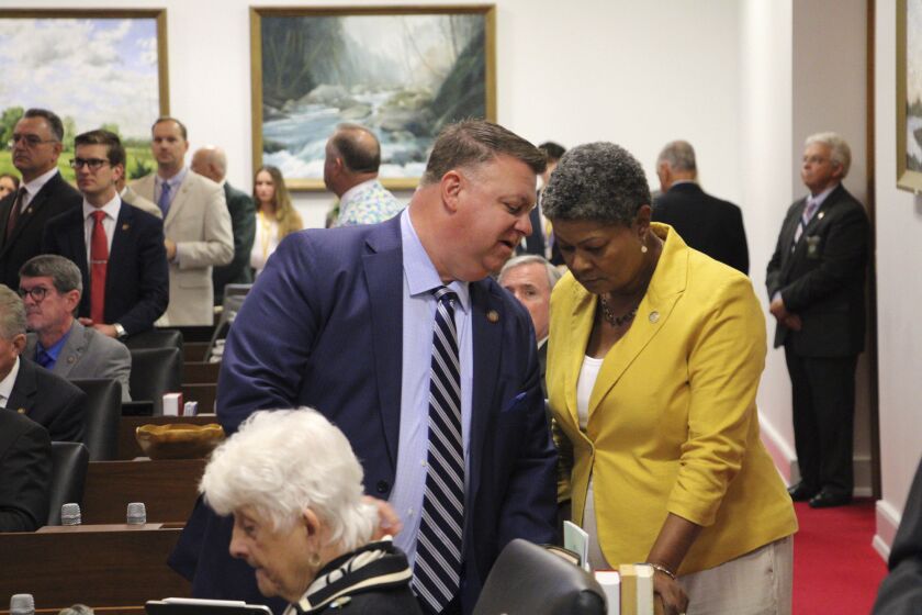North Carolina state Reps. Jason Saine, left, R-Lincoln, and Rep. Carla Cunningham, D-Mecklenburg, confer on the House floor in the Legislative Building in Raleigh, N.C., on Wednesday, June 7, 2023. Saine is a chief sponsor of a bill to legalize sports gambling and horse-race betting statewide that received final General Assembly approval later Wednesday. The bill now goes to Gov. Roy Cooper's desk (AP Photo/Gary D. Robertson)