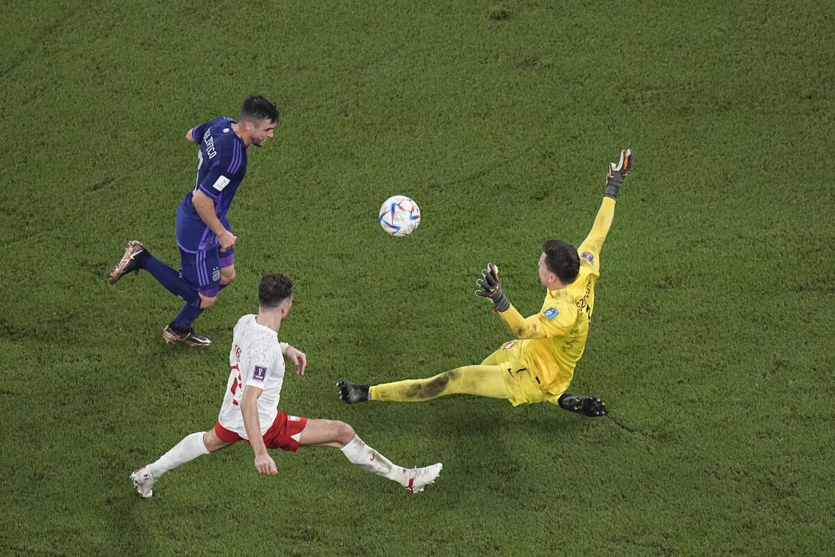 Argentina's Nicolas Tagliafico, left, misses an opportunity to score in front of Poland goalkeeper Wojciech Szczesny .