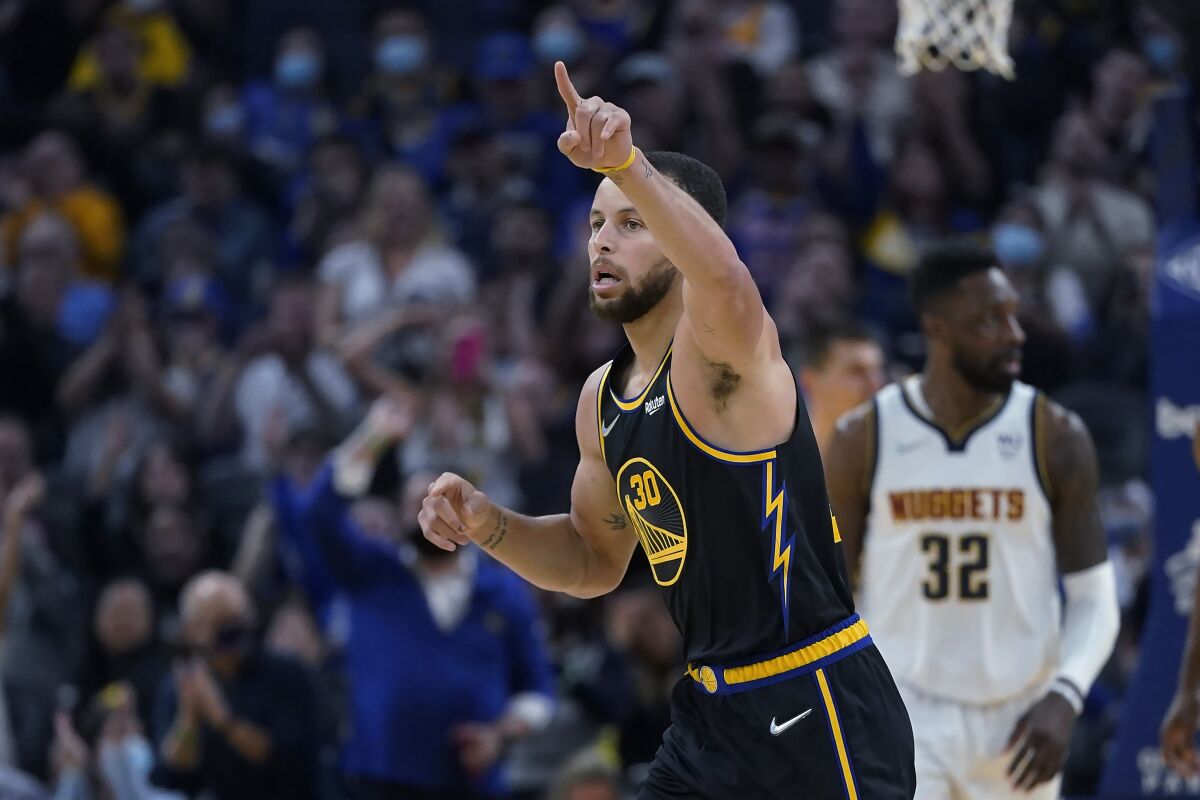 Golden State Warriors guard Stephen Curry celebrates after making a 3-point basket against the Denver Nuggets during the first half of an NBA basketball game in San Francisco, Wednesday, Feb. 16, 2022. (AP Photo/Jeff Chiu)