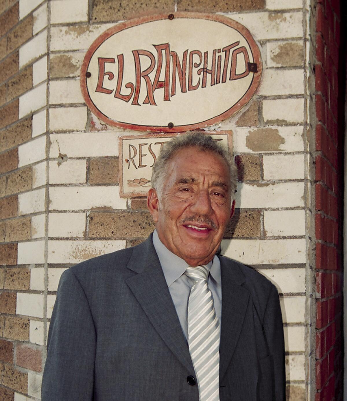 Salvador Avila stands beneath an El Ranchito sign.