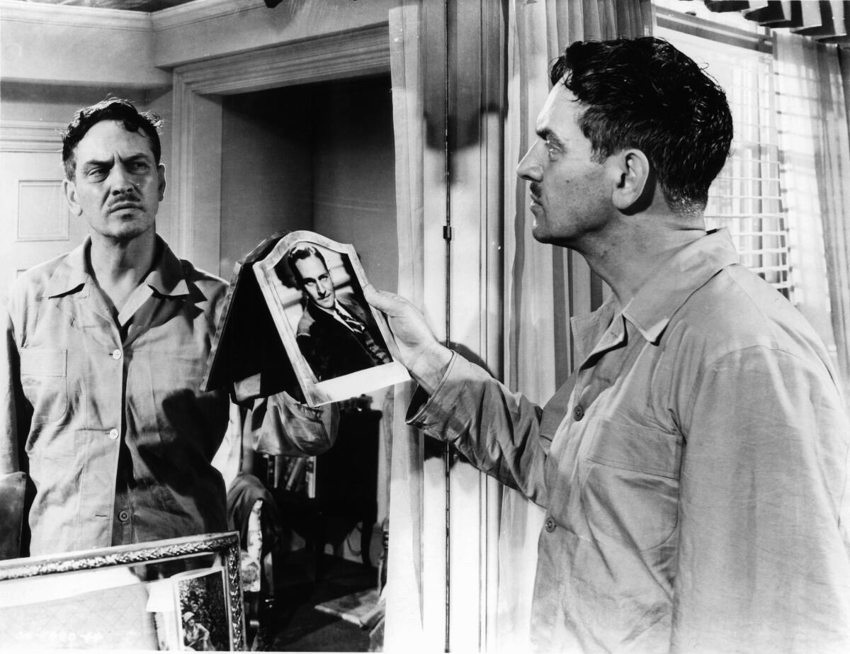 Fredric March, portraying Al, looks into a mirror while holding a photo of his younger self