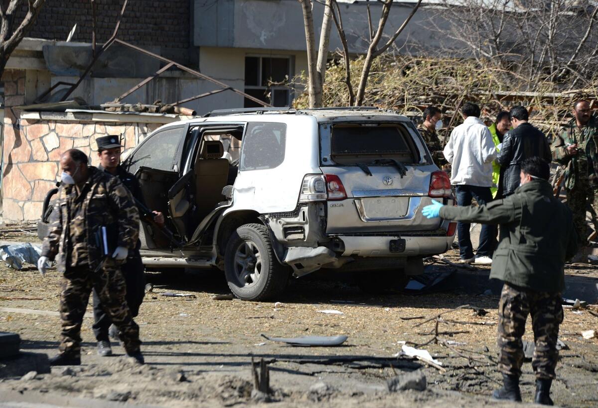 Afghan investigators inspect the site where a suicide bomber targeted a vehicle convoy of Afghan lawmakers in Kabul on Sunday.