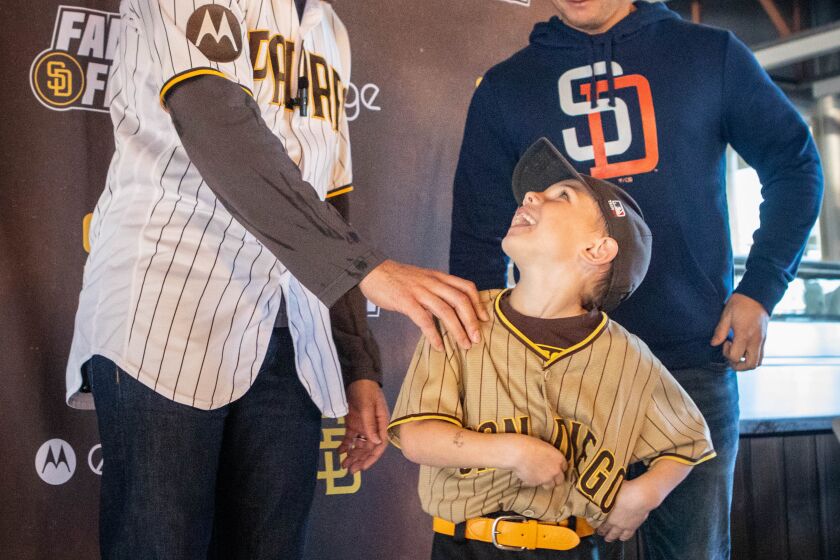San Diego, CA - February 04: Brantley Bowen, 5, of San Diego, shows his jersey to Manny Machado during the Padres' 2023 FanFest at Petco Park on Saturday, Feb. 4, 2023 in San Diego, CA. (Meg McLaughlin / The San Diego Union-Tribune)