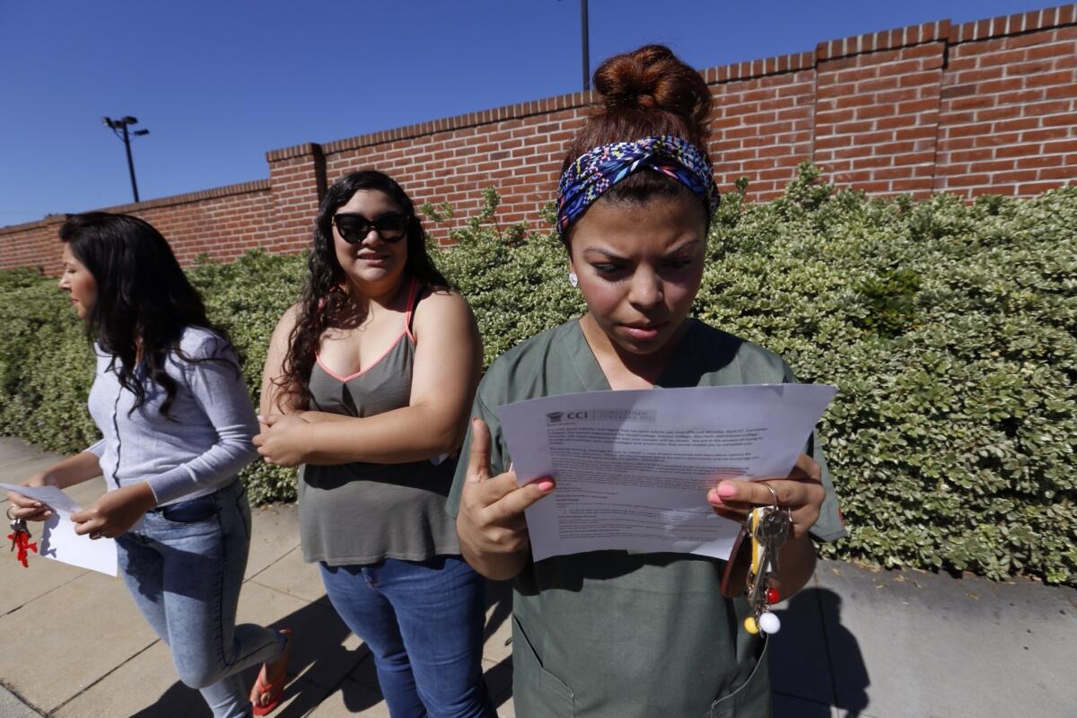 Ruby Maldanado, a medical assistant student, checks a note handed out to students who were turned away at the gate of Everest College in Alhambra, one of the Corinthian Colleges that closed April 27, 2015.