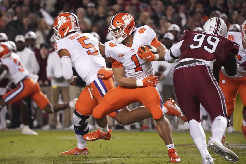 Clemson running back Will Shipley (1) carries next to South Carolina defensive lineman Jabari Ellis (99) during the first half of an NCAA college football game Saturday, Nov. 27, 2021, in Columbia, S.C. (AP Photo/Sean Rayford)