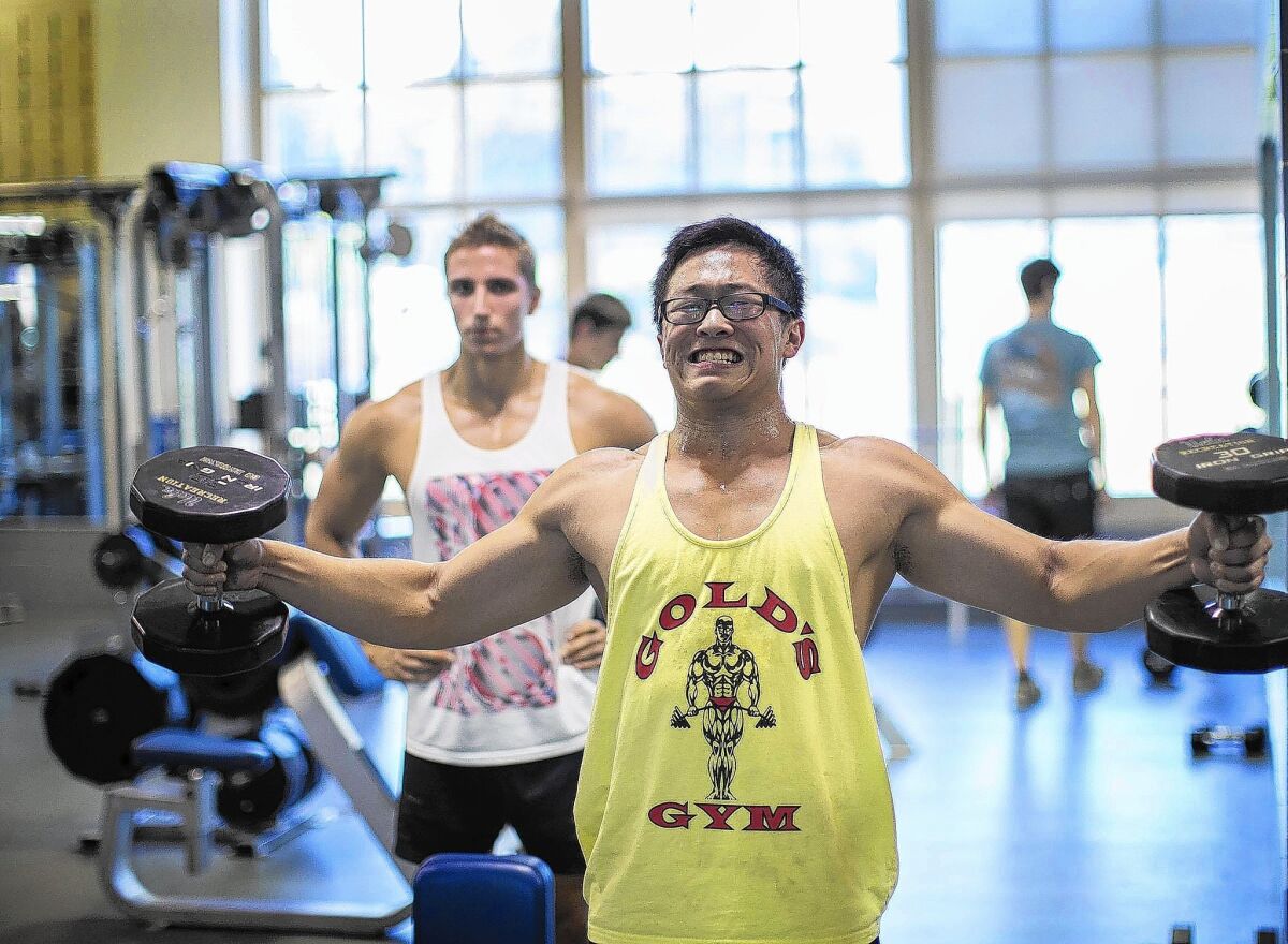 UCLA student Eric Wang, 20, right, and his workout bro Eric Neufeld, 20, lift weights at the John Wooden Center.