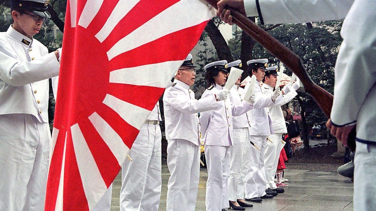 The imperial Japanese battle flag with the rising sun is held during a ceremony at Yasukuni Shrine in Tokyo to honor those killed in war.