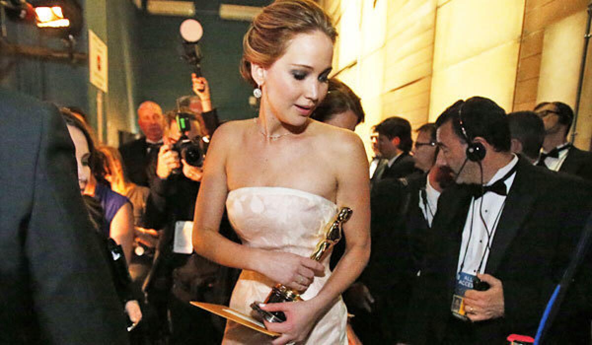 Jennifer Lawrence backstage holding her Oscar in 2013.