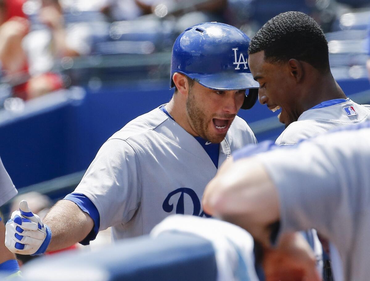 Dodgers catcher Drew Butera, left, is greeted by second baseman Dee Gordon after hitting a two-run home run Thursday against the Atlanta Braves.