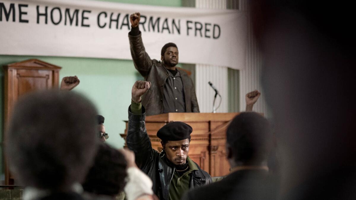 A Black leader at a lectern raises his fist in a power salute.