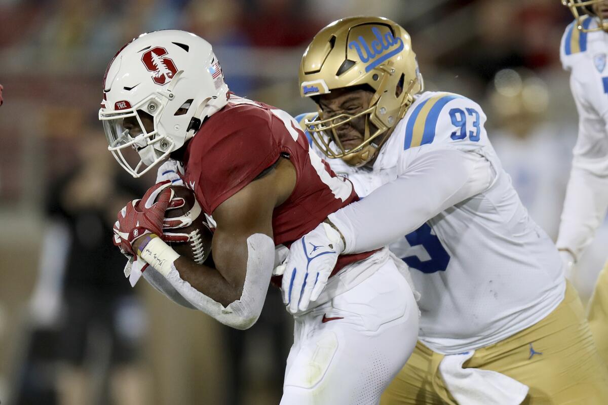 UCLA's Jay Toia wraps up Stanford running back E.J. Smith 