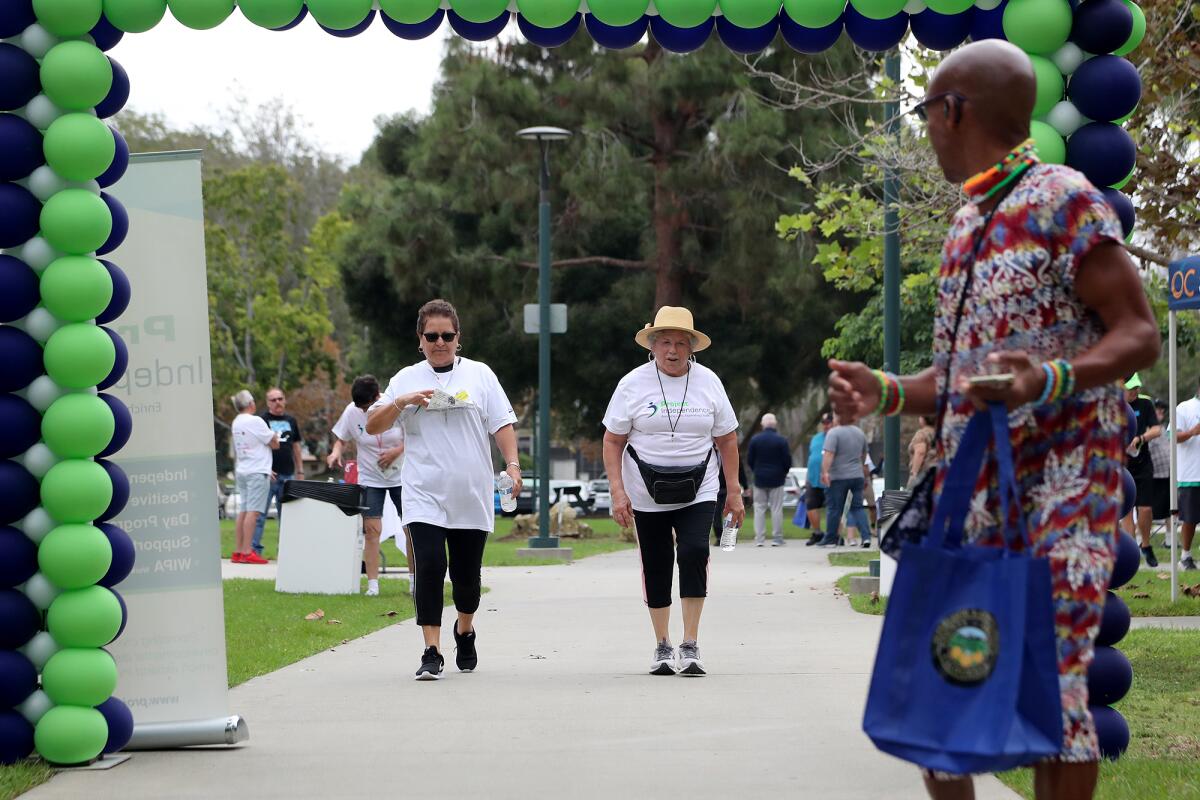 Participants walk during the 13th Annual Walk for Independence at TeWinkle Park on Saturday in Costa Mesa. 