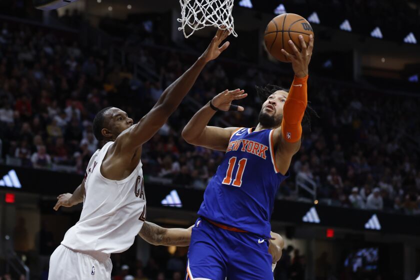 New York Knicks guard Jalen Brunson (11) shoots against Cleveland Cavaliers forward Evan Mobley, left, during the second half of an NBA basketball game, Friday, March 31, 2023, in Cleveland. (AP Photo/Ron Schwane)