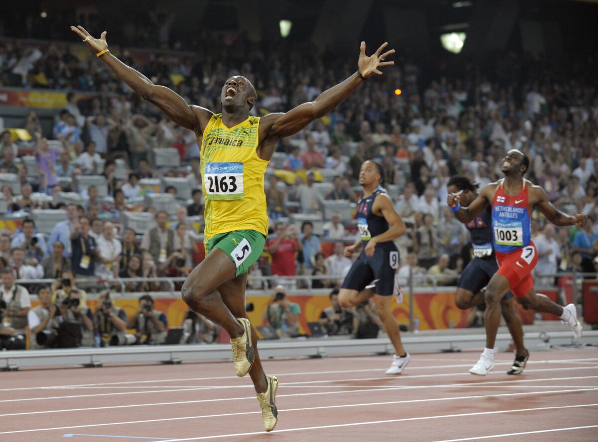 File-Jamaica's Usain Bolt celebrates as he wins the men's 200-meter final with a world record during the athletics competitions in the National Stadium at the Beijing 2008 Olympics in Beijing, Wednesday, Aug. 20, 2008. The Olympics are remembered for the stars. That was true in Beijing in 2008, and the stars were Michael Phelps and Bolt. But Beijing is also storied for its signature venues like the “Bird's Nest” stadium, and the “Water Cube” swimming venue. No Olympics before — or since — have impacted a city the way the Olympics did Beijing. (AP Photo/Thomas Kienzle, File)