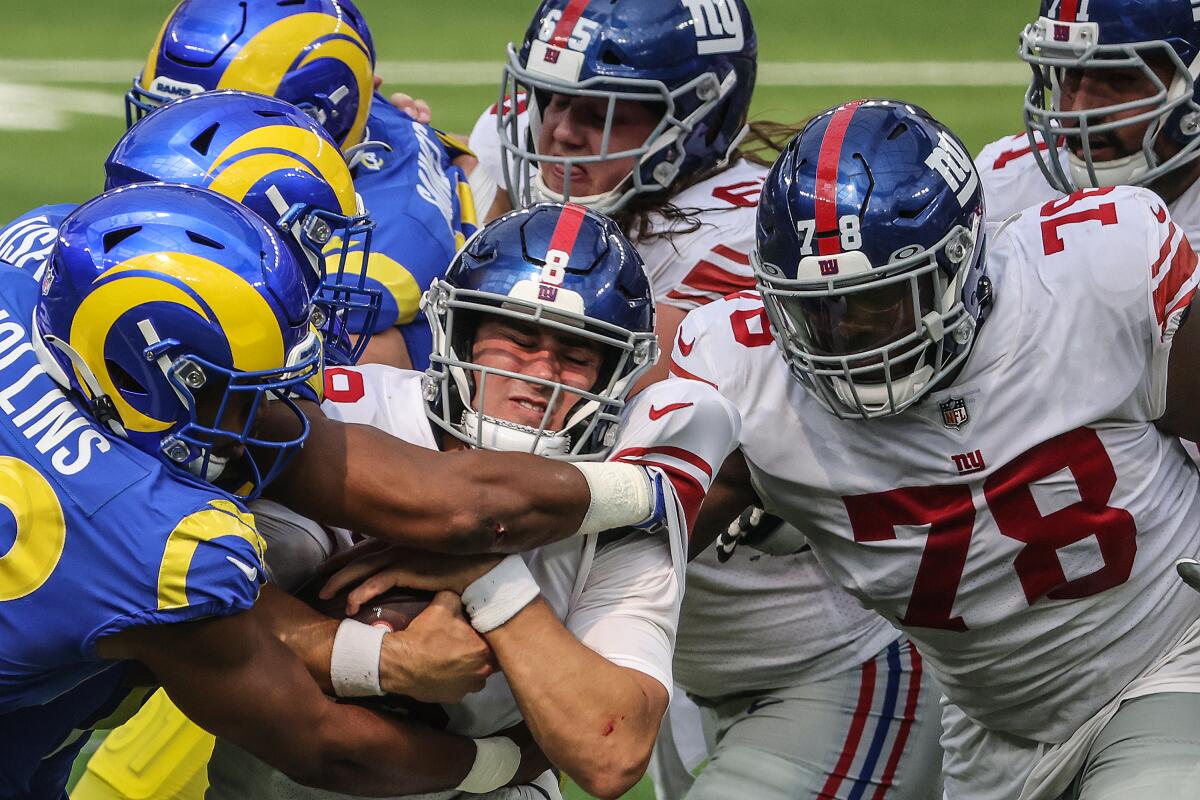 Rams defenders stop New York Giants quarterback Daniel Jones on a short run in the second quarter at SoFi Stadium on Sunday.