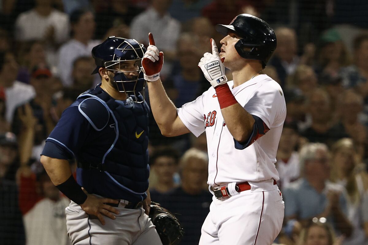 As Tampa Bay Rays catcher Mike Zunino looks on, Boston Red Sox's Hunter Renfroe points skyward after hitting a two run home run during the eighth inning of a baseball game Wednesday, Sept. 8, 2021, at Fenway Park in Boston. (AP Photo/Winslow Townson)