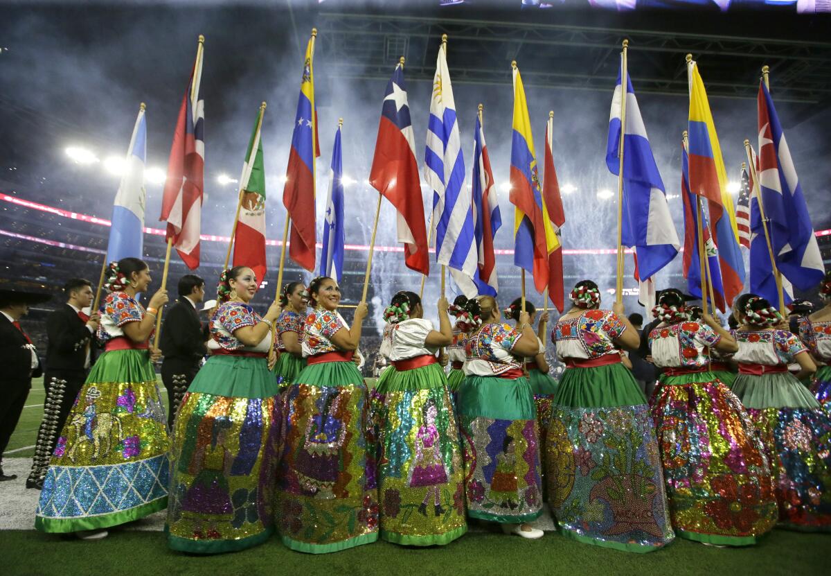 FILE - Dancers with the Ballet Folklorico De San Antonio carry flags from different Latin countries as they participate in a ceremony celebrating Hispanic Heritage Month before an NFL football game between the Chicago Bears and Dallas Cowboys, Sept. 25, 2016, in Arlington, Texas. Hispanic history and culture take center stage across the U.S. for National Hispanic Heritage Month. The celebration recognizes contributions made by Hispanic Americans, the fastest-growing racial or ethnic minority according to the Census, and with a U.S. population of over 63 million people, there will be a plethora of Hispanic Heritage Month celebrations all over the country starting Friday, Sept. 15, 2023. (AP Photo/LM Otero, File)