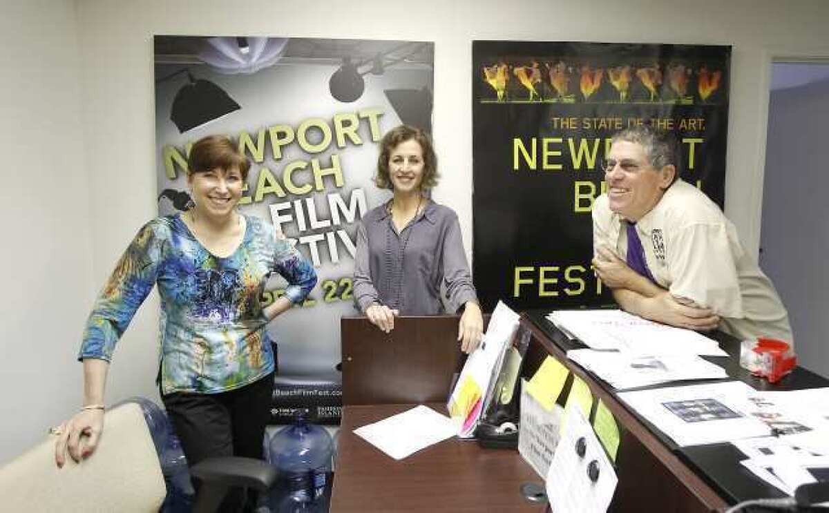From left, Newport Beach Film Festival volunteers Riki Kucheck, Leslie Feibleman, and Dennis Baker, get ready for this week's film festival in their Newport Beach offices.