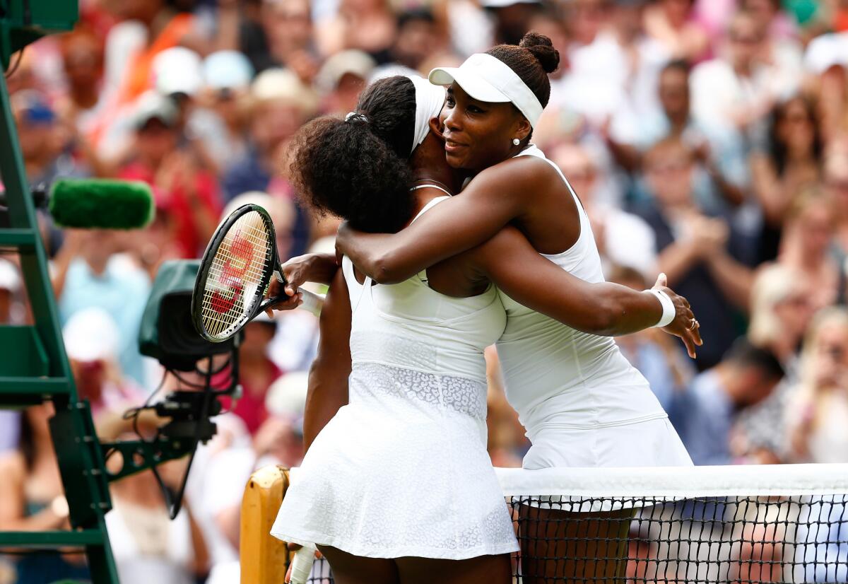 Sisters Serena Williams and Venus Williams share a hug after their fourth-round Wimbledon match last summer