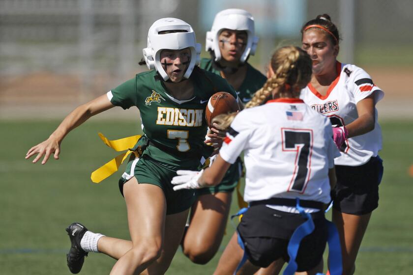 Edison receiver Emma Valenzuela looks for a gap in the defense as runs upfield during girls' Sunset League flag football game against Huntington Beach on Wednesday.