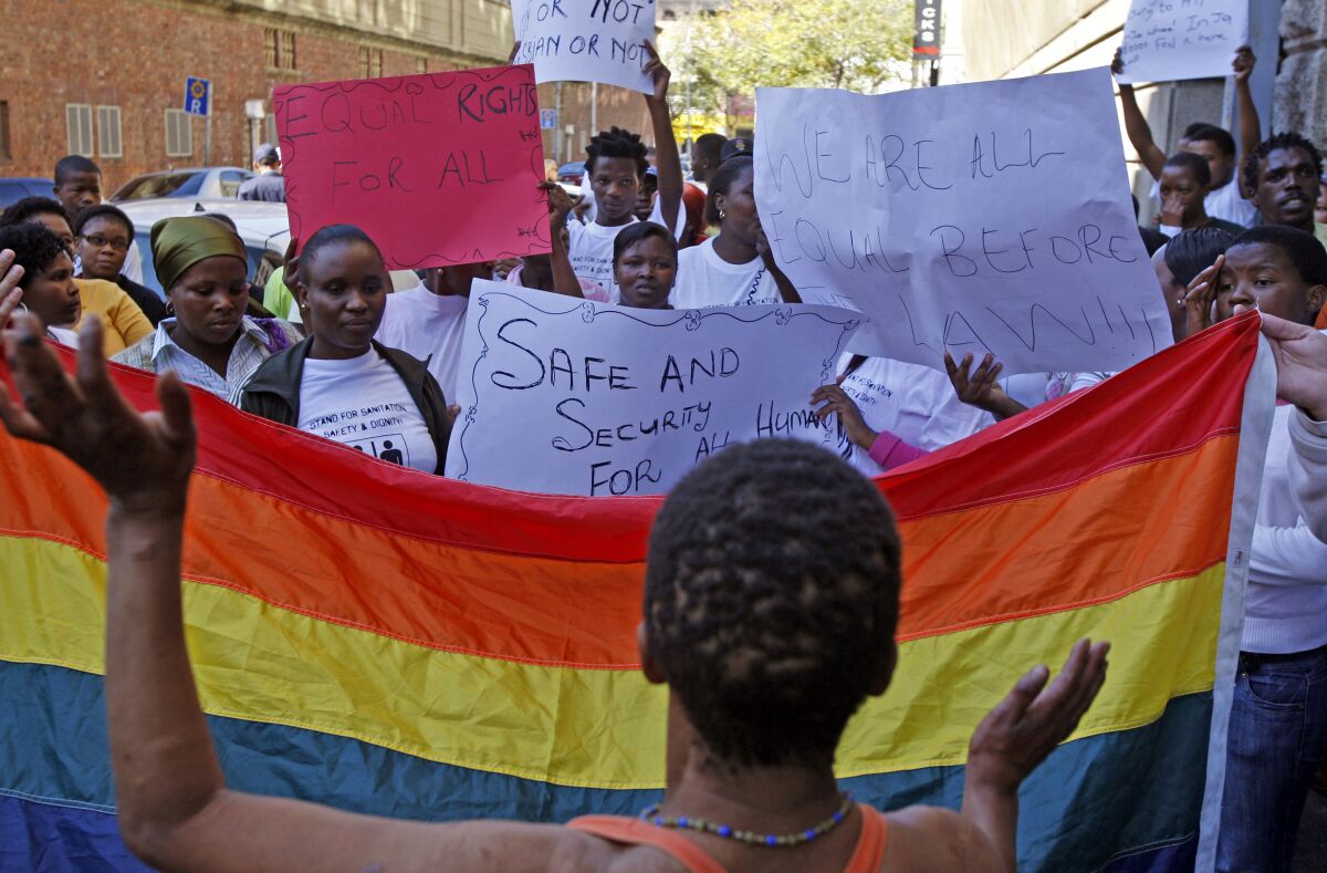 Women with rainbow flag at a protest in South Africa