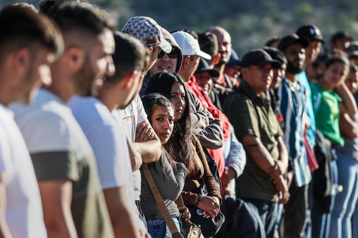 Migrants stand in a line