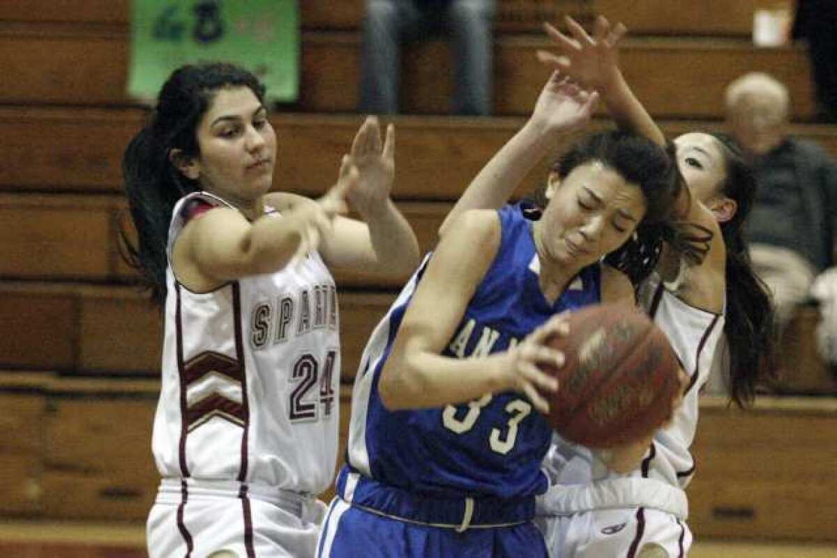 La Canada's Aundrea Issakhanian, left, and Courtney Chen, right, play defense on San Marino's Tiffany Meihls in a 48-41 Spartans' victory.