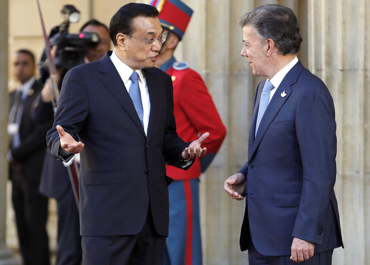 El primer ministro chino Li Keqiang, izquierda, habla con el presidente colombiano Juan Manuel Santos, derecha, durante una ceremonia de bienvenida en el Palacio Presidencial de Bogotá, Colombia, el jueves 21 de mayo de 2015. Li Keqiang realiza una visita oficial de dos días a Colombia, y después viajará a Perú y Chile.