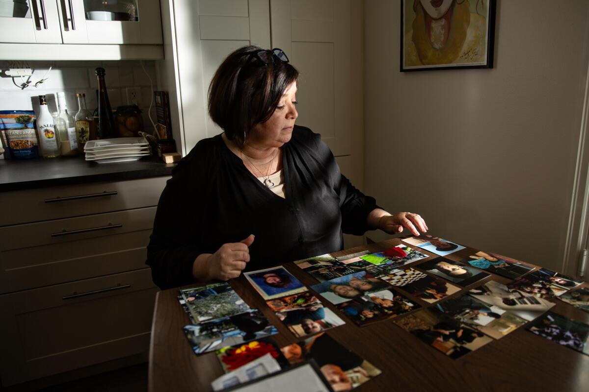 Deborah Smith sits at her dining room table looking over photos 