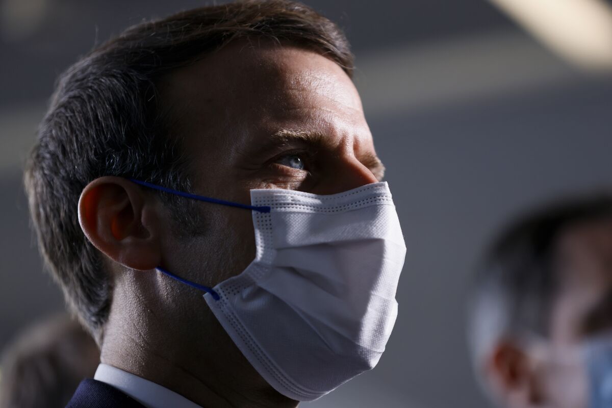 French President Emmanuel Macron looks on as he visits the IMAGINE Institute at the Necker Hospital, Friday Dec. 4, 2020 in Paris. (Thomas Samson, Pool via AP)