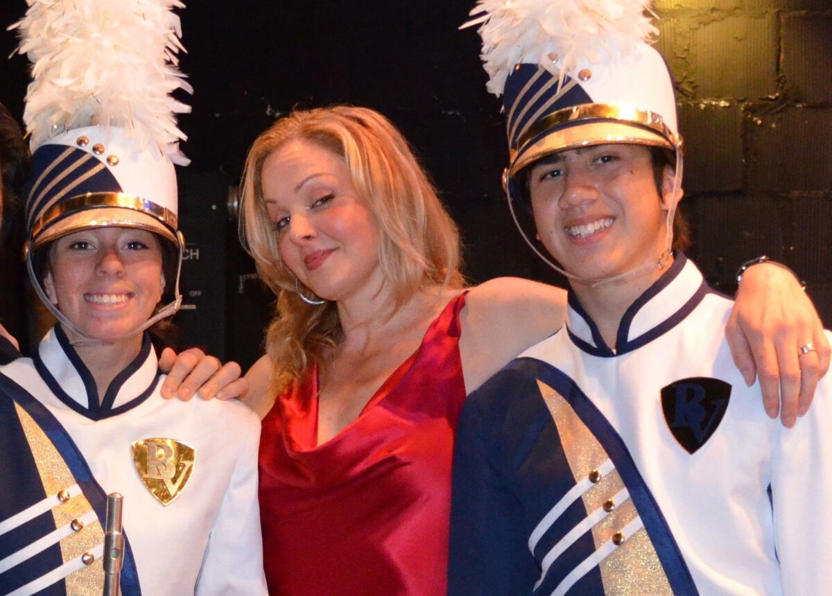 Storm Large (center), one of the two female singers in Pink Martini, poses with Bonita Vista High School Club Blue Marching Band members Lorena Lopez (left) and Kyle McConkey at San Diego's Balboa Theatre in 2011.