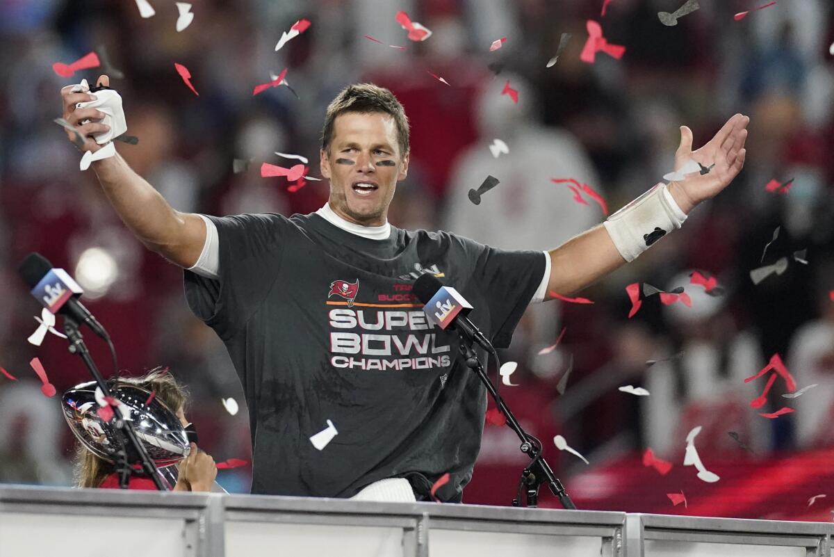 Tampa Bay Buccaneers quarterback Tom Brady raises his hands amid confetti.