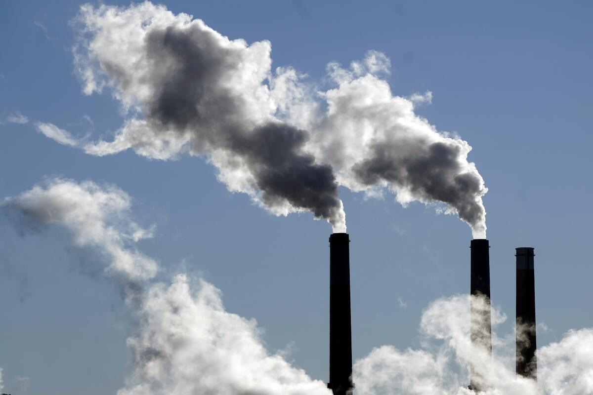 Steam is emitted from smoke stacks at a coal-fired power plant Nov. 17, 2021, in Craig, Colo. 