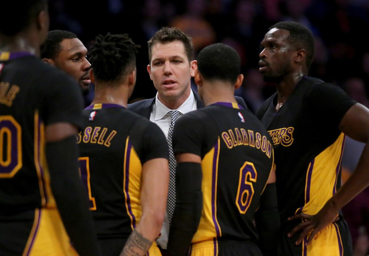 Lakers Coach Luke Walton huddles with his team during a break in play against the Heat in the third quarter Friday.