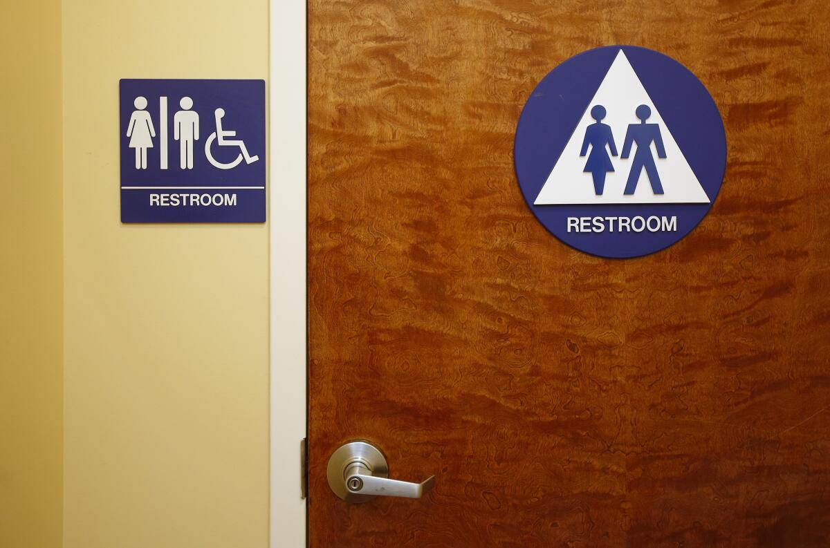 A restroom with a sign indicating it is for all genders