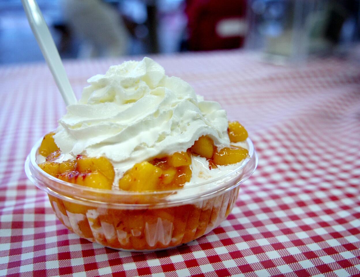 Low-fat vanilla frozen yogurt with fresh peaches and whipped cream.
