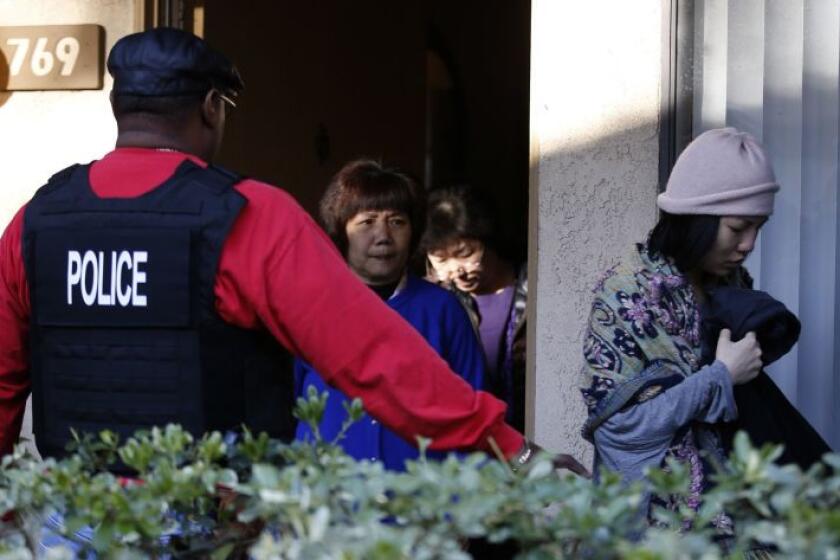 Federal agents escort residents from an apartment in Rowland Heights during a 2015 raid on an alleged “birth tourism” operation. On Thursday, prosecutors charged several people in such schemes, which bring pregnant women to the U.S to give birth