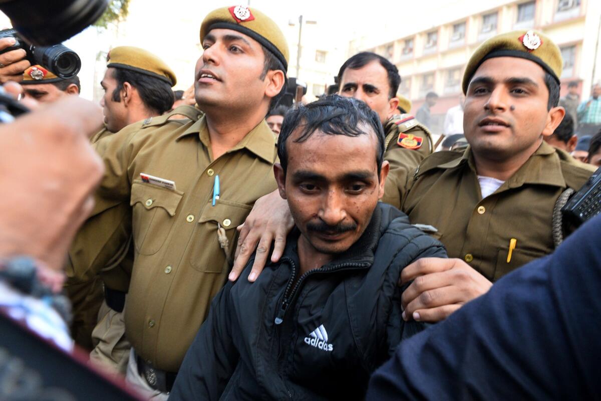 Indian police escort Uber taxi driver Shiv Kumar Yadav, in a dark Adidas jacket, following his court appearance in New Delhi on rape charges.