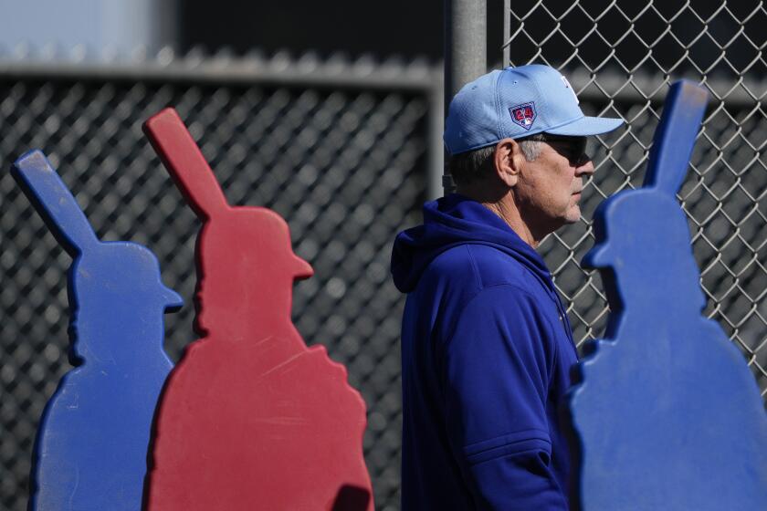 Texas Rangers manager Bruce Bochy watches a bullpen session during spring training baseball workouts Wednesday, Feb. 14, 2024, in Surprise, Ariz. (AP Photo/Lindsey Wasson)