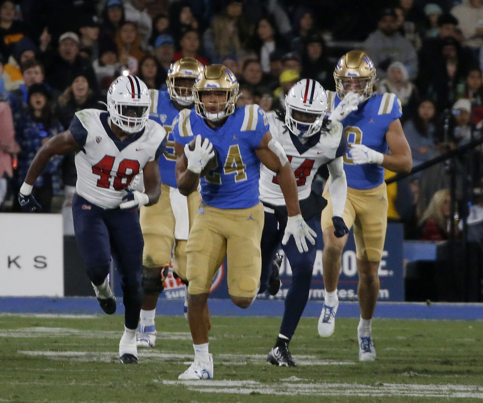 UCLA Zach Charbonnet runs for a big gain against Arizona.