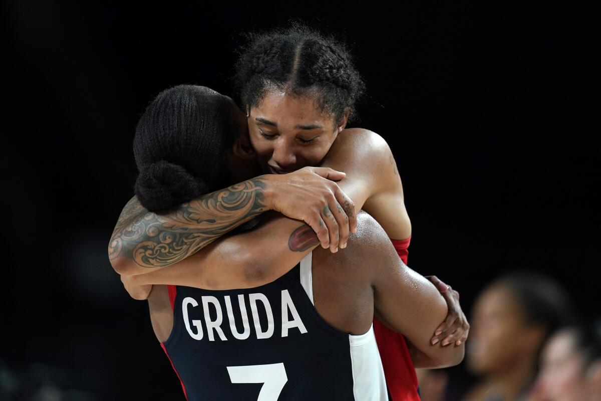 France's Gabrielle Williams gets a hug from teammate Sandrine Gruda at the end of the women's basketball bronze medal game against Serbia at the 2020 Summer Olympics, Saturday, Aug. 7, 2021, in Saitama, Japan. (AP Photo/Charlie Neibergall)