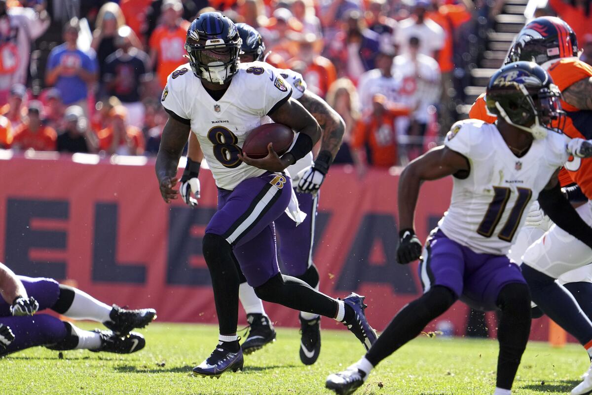 Ravens quarterback Lamar Jackson runs with the ball at Denver on Oct. 3, 2021.