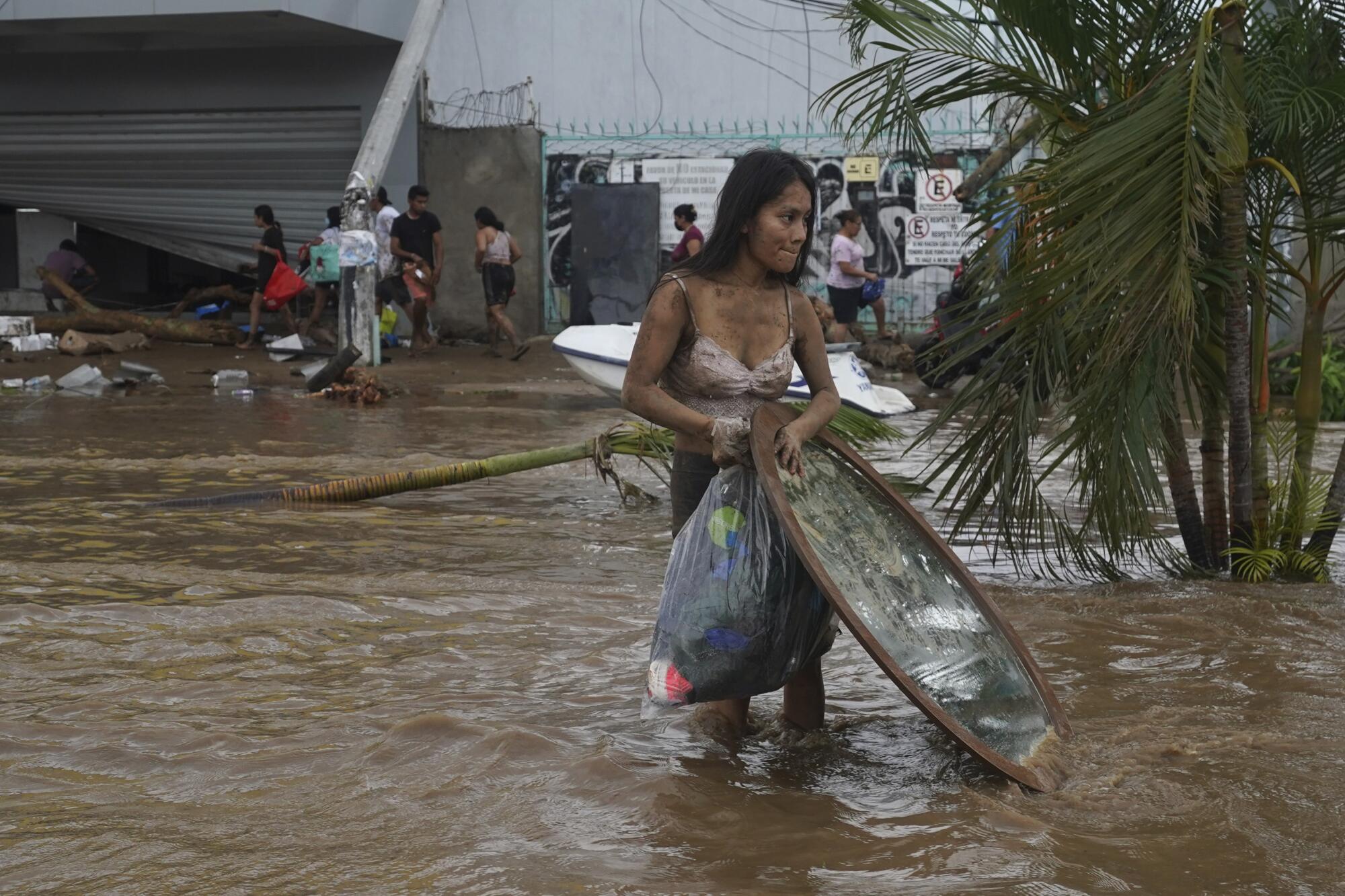 A woman walks through floodwaters in Acapulco