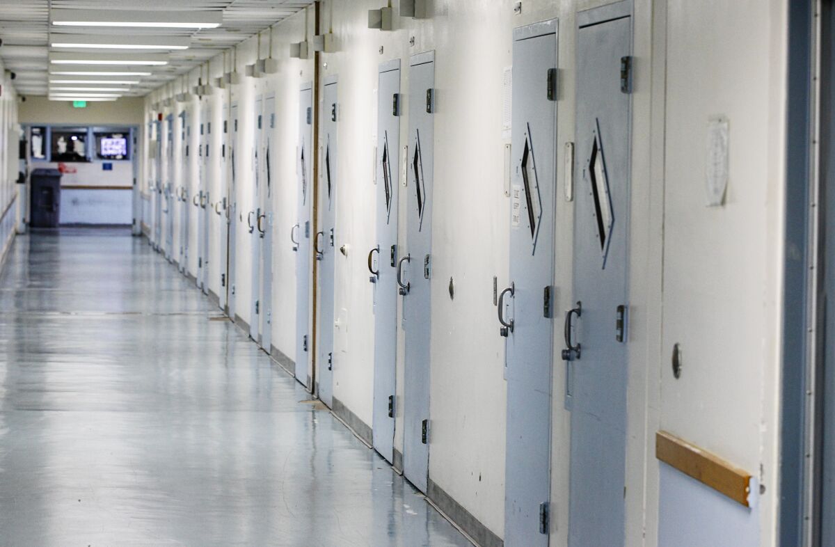 A hallway lined with youth cells at a juvenile detention facility.