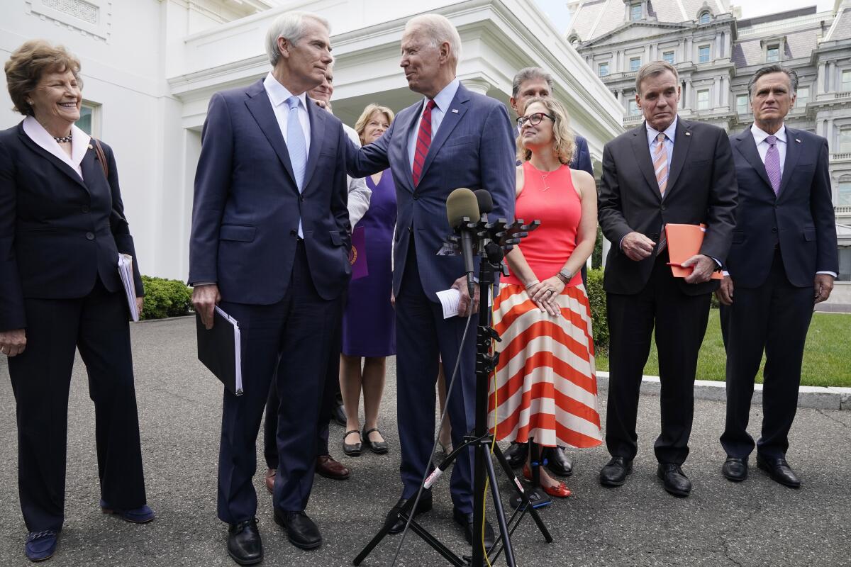 President Biden and a group of senators prepare to address reporters outside the White House.
