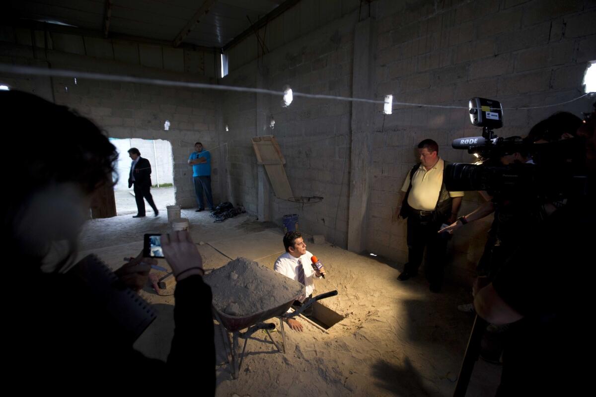 En esta imagen del martes 14 de julio de 2015, un periodista informa desde la salida del túnel por el que, según las autoridades, escapó el capo de la droga Joaquín "El Chapo" Guzmán de la prisión de máxima seguridad de Altiplano, en Almoloya, al oeste de la ciudad de México.