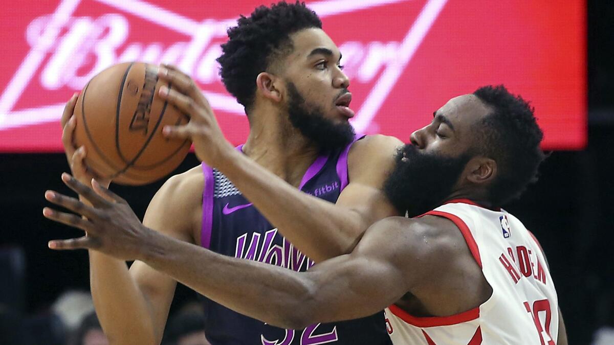Timberwolves center Karl-Anthony Towns is closely defended by Rockets guard James Harden during a game Feb. 13.