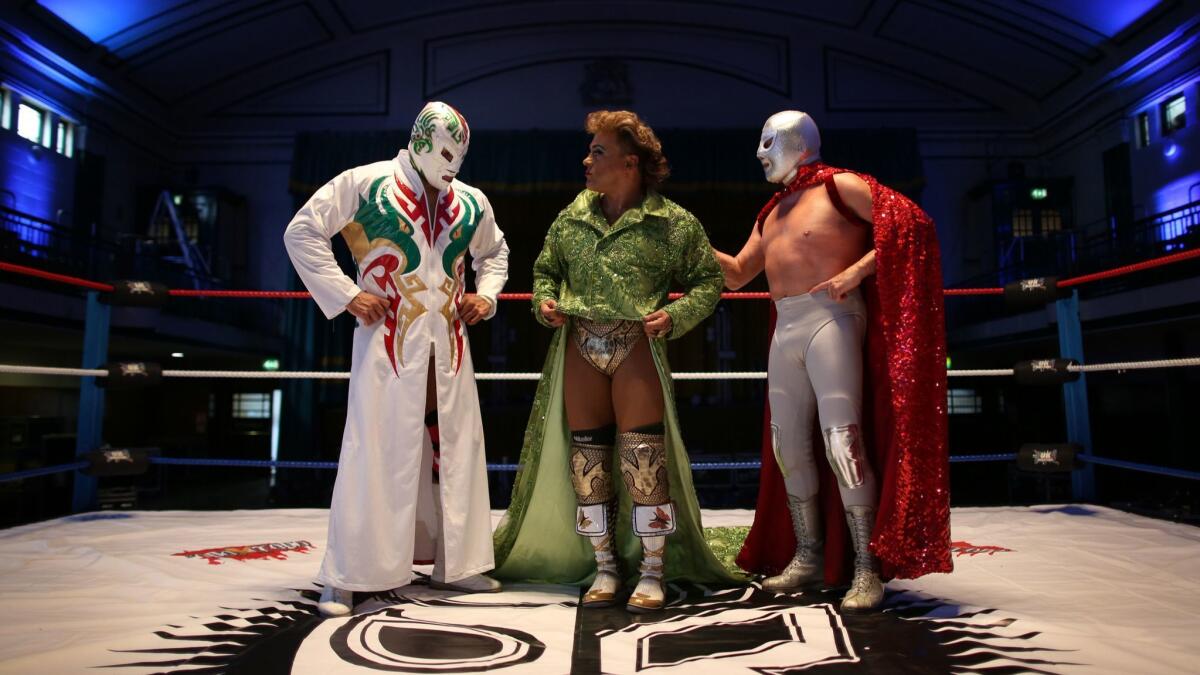 El luchador mexicano Cassandro, al centro, acompañado por Dr. Wagner Jr. (izq.) y El Hijo del Santo, en Londres el 8 de julio de 2015. PETER MACDIARMID/GETTY