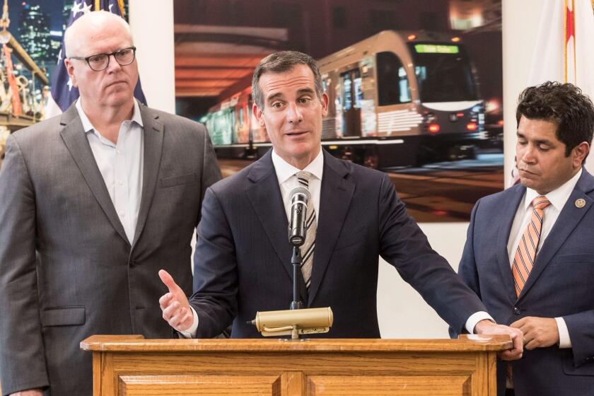 LOS ANGELES, CALIF. -- MONDAY, NOVEMBER 27, 2017: Los Angeles mayor Eric Garcetti, center, speaks flanked by Congressman Jimmy Gomez, right, and House Democratic Caucus Chairman Joe Crowley, left, during press conference at Metro Headquarters in Los Angeles, Calif., on Nov. 27, 2017. (Brian van der Brug / Los Angeles Times)